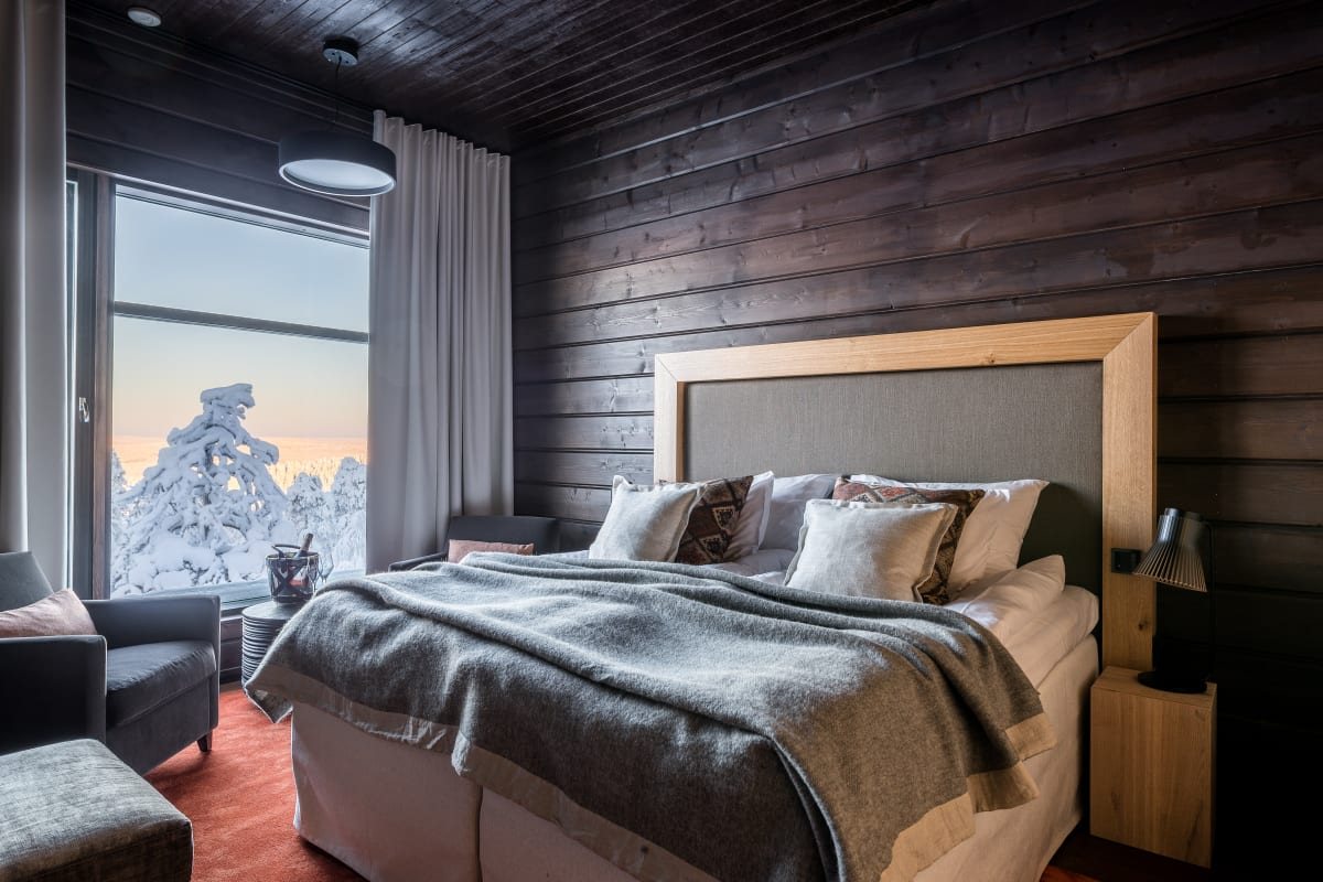 A bedroom at Octola Private Wilderness with a snowy forest view through the window