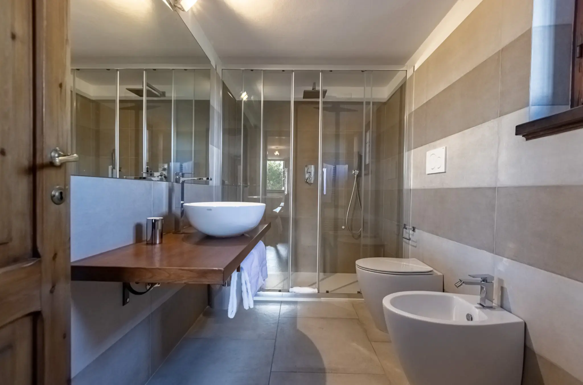 Modern bathroom with stone finishes at Villa Serenzia, Val d’Orcia