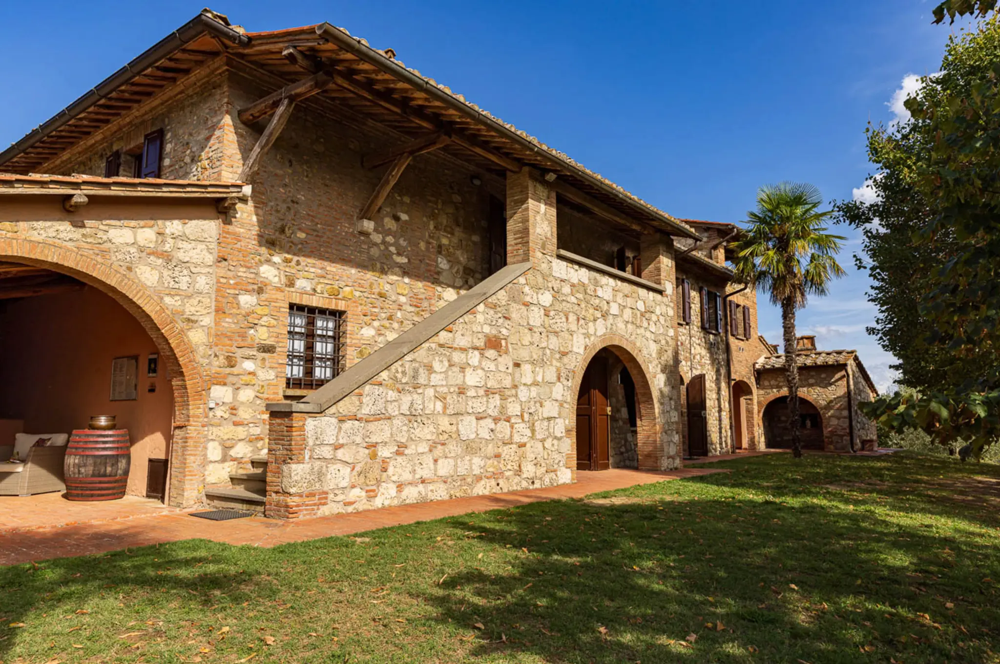 Stone farmhouse facade of Villa Serenzia in Tuscany with terracotta roof tiles